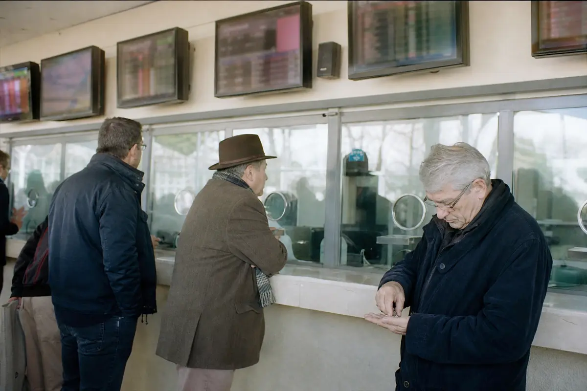 Guichets de paris d'un hippodrome avec des parieurs qui font la queue avant une course
