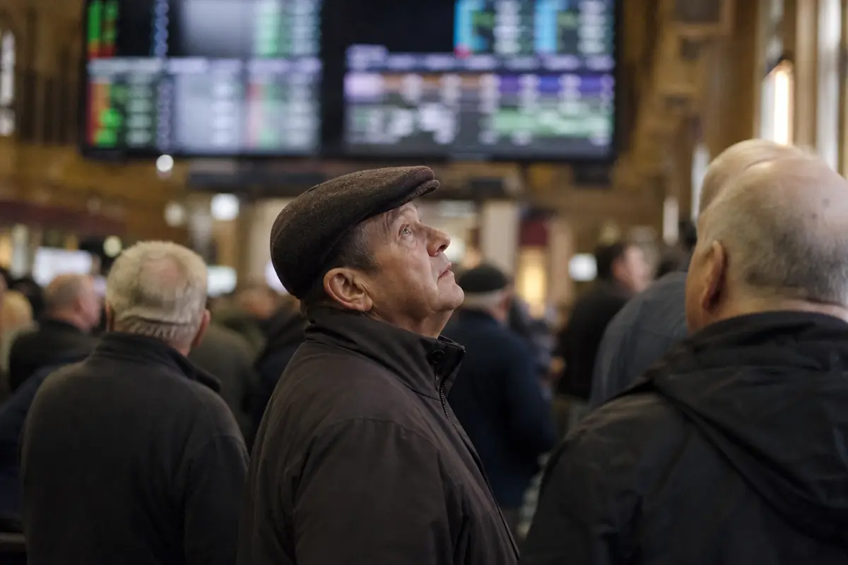 Un parieur regarde les cotes sur un écran à l'hippodrome