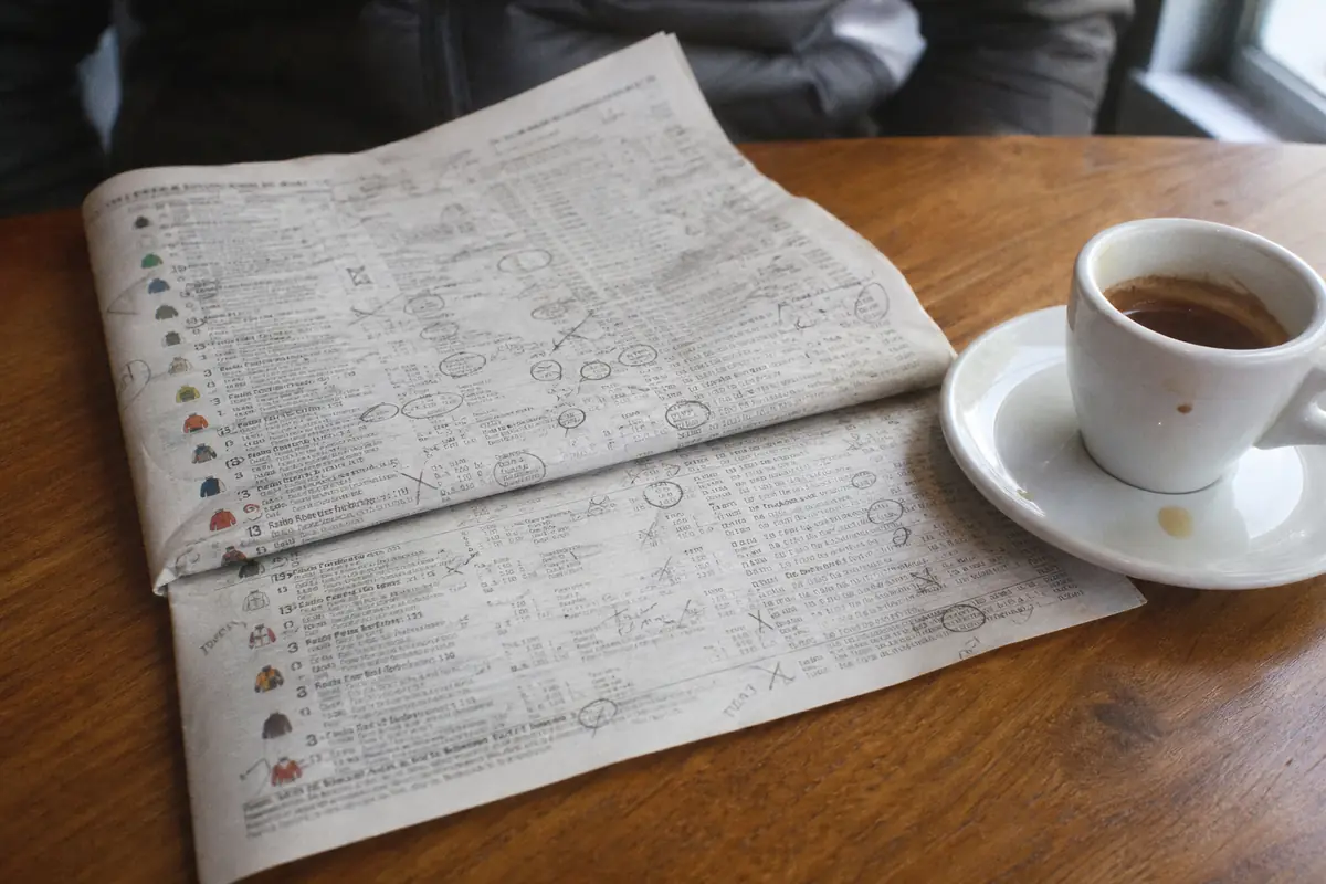 Programme de courses imprimé, annoté au crayon, posé sur une table de café