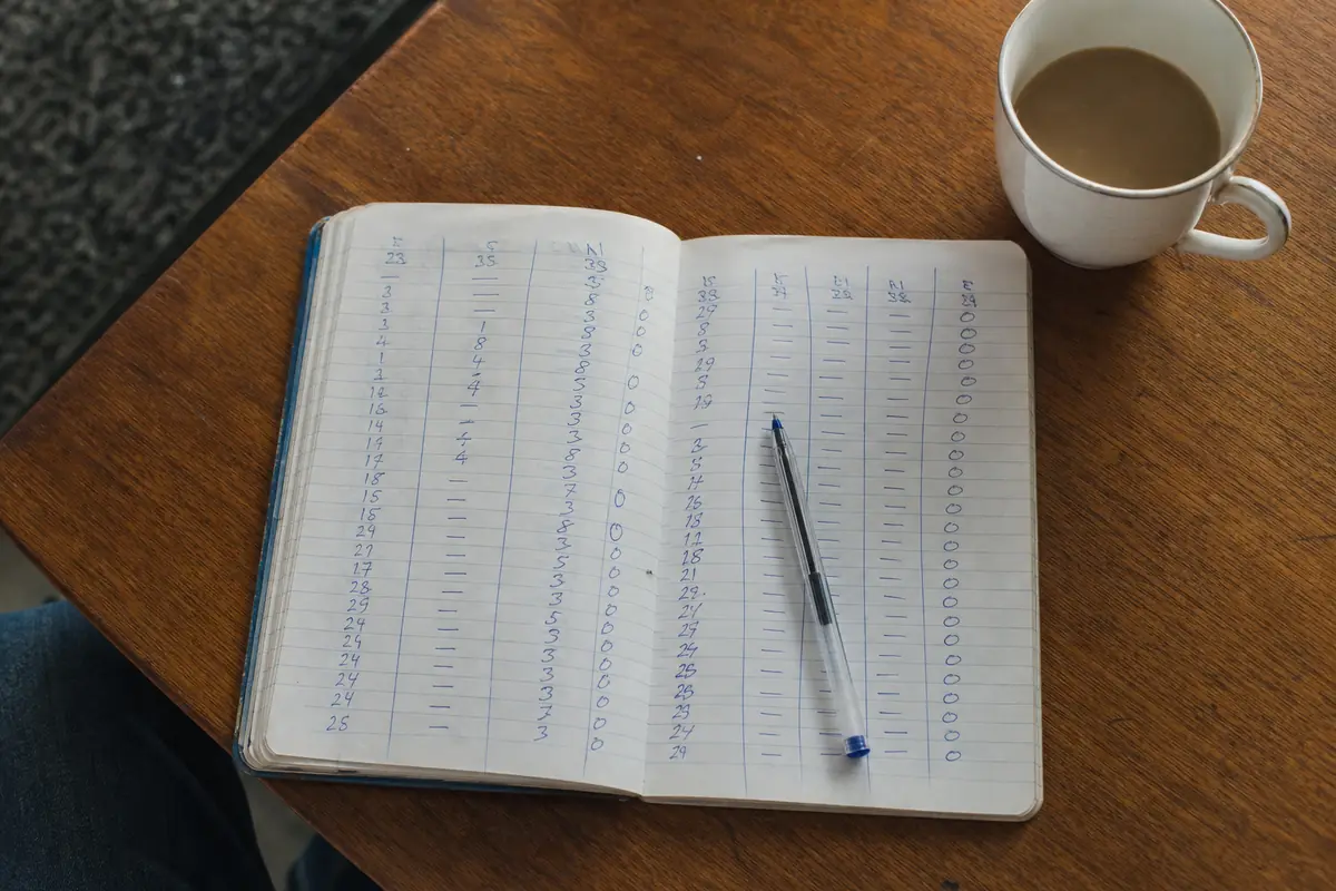 Carnet de paris ouvert avec des colonnes de chiffres écrites à la main