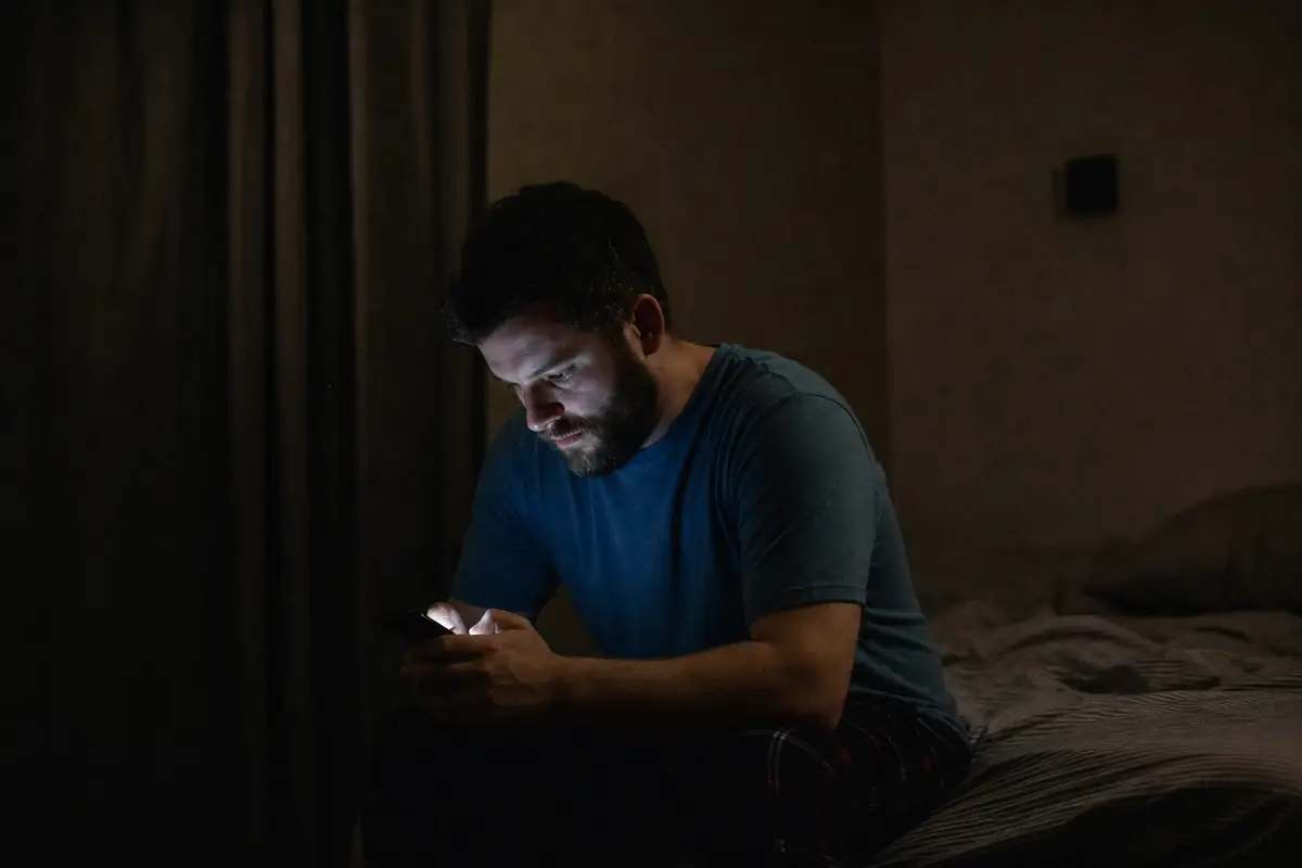 Un homme seul tard le soir devant l'écran de son téléphone