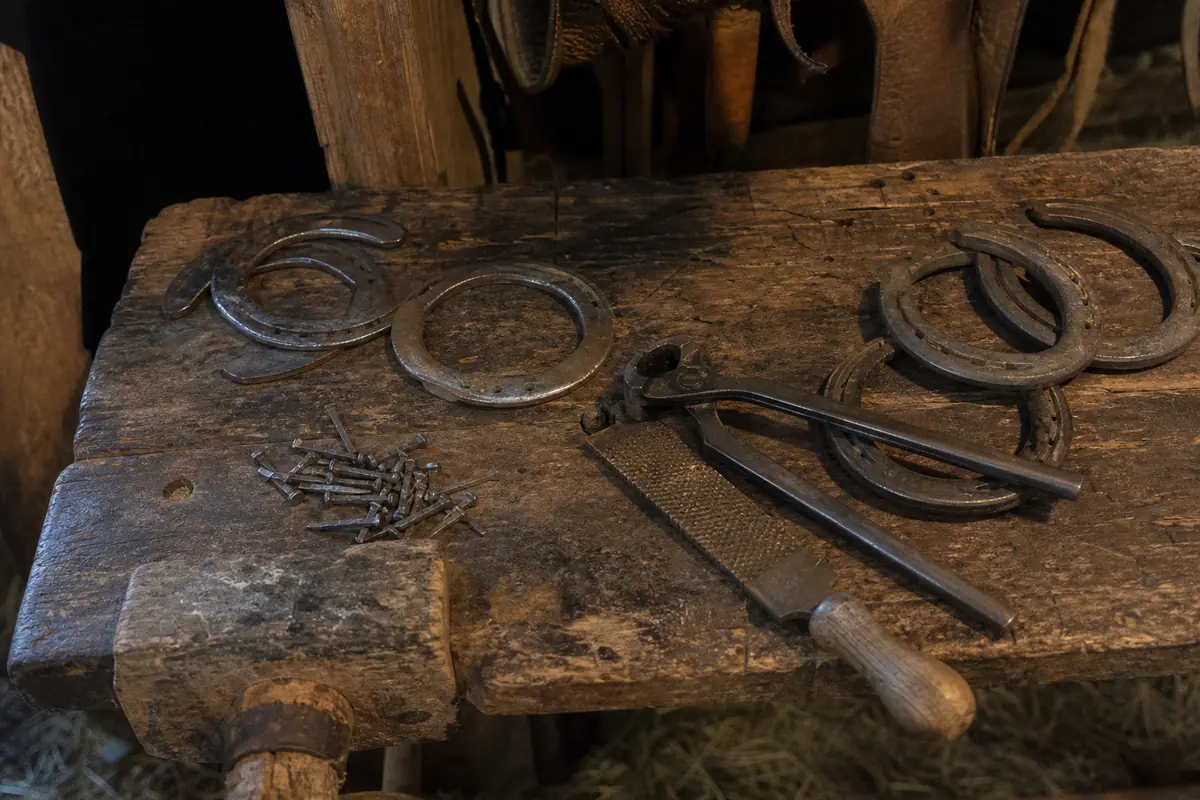 Fers à cheval et outils de maréchal-ferrant sur un établi